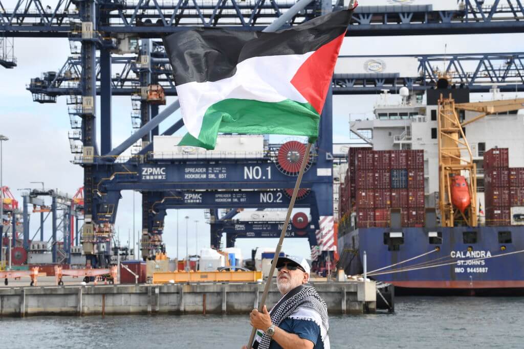 SYDNEY, AUSTRALIA - NOVEMBER 21: Protestors from the Australian Palestinian community gather at Port Botany beside a container ship on November 21, 2023 in Sydney, Australia. The Pro-Palestinian demonstrators have been targeting the Israeli shipping company ZIM claiming the company is a transporter of weapons to Israel. (Photo by James D. Morgan/Getty Images)